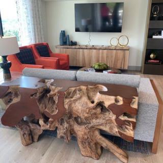 A modern living room featuring a unique wooden table and comfortable seating.