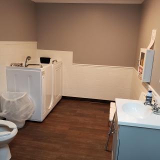 A combined bathroom and laundry room featuring a toilet, washing machine, and sink.