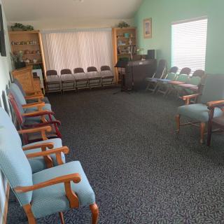 A spacious waiting room with multiple chairs arranged around the walls, offering a comfortable seating area.