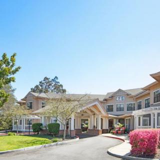 A sunny day view of a residential building with landscaped surroundings.