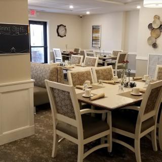 A neatly arranged dining room with elegantly set tables and chairs.