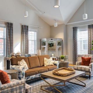 A modern and cozy living room interior with a brown sofa, patterned armchairs, and a stylish coffee table.