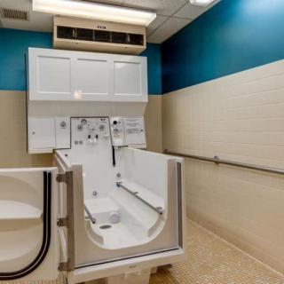 An accessible bathtub with safety features in a healthcare facility bathroom.