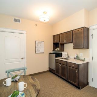 Cozy apartment kitchen with modern cabinetry and dining area.