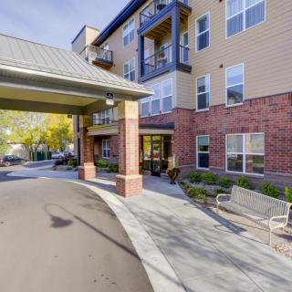 A modern residential building with a welcoming entrance and outdoor seating.