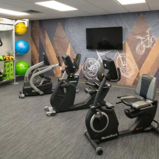 A modern gym featuring stationary bikes and colorful exercise balls.