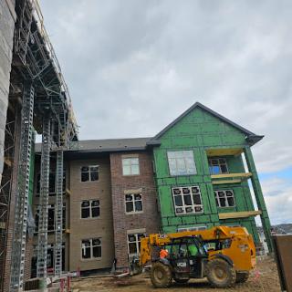 A construction site showcasing a building in progress, featuring scaffolding and heavy machinery.