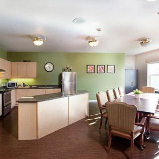 A modern kitchen and dining area with green walls and contemporary furniture.