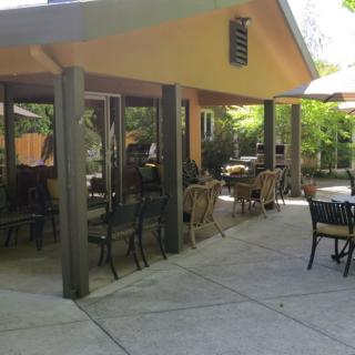 Outdoor seating area of a restaurant with tables and chairs on a sunny day.