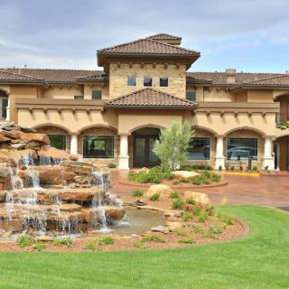 A luxury building with a cascading fountain and landscaped garden.