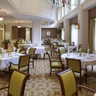 An elegant dining area with neatly arranged tables and chairs in a formal setting.