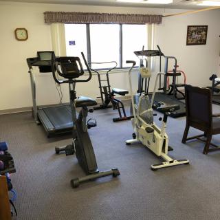 A small indoor gym with various exercise equipment including treadmills and stationary bikes.