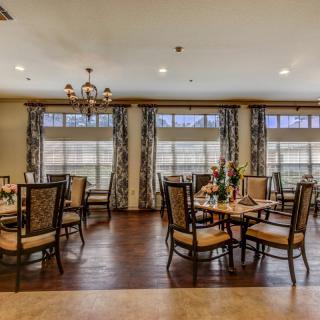 A beautifully decorated dining room with elegant tables and chairs set on a polished wooden floor.
