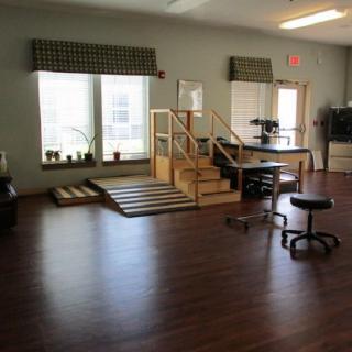 A rehabilitation room equipped with exercise stairs and various physical therapy tools.