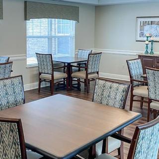 A neatly arranged dining area with several tables and chairs.