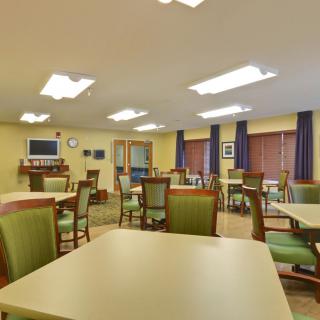 A well-lit dining area with tables and chairs arranged neatly.