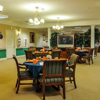 A cozy dining room with elegantly set tables and soft lighting.