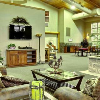 A spacious and modern living room featuring comfortable seating, a wall-mounted television, and tasteful decor.