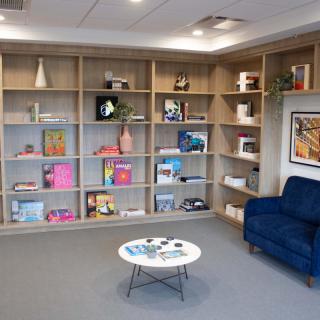 A cozy reading nook featuring modern bookshelves and a comfortable armchair.