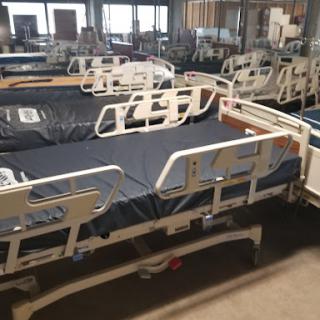 A row of hospital beds arranged in a healthcare facility.
