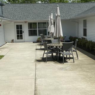 An outdoor patio area with tables and chairs under umbrellas.