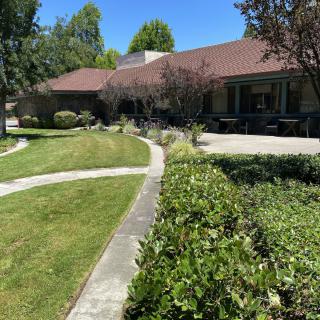 A picturesque house with a manicured garden and pathway on a sunny day.