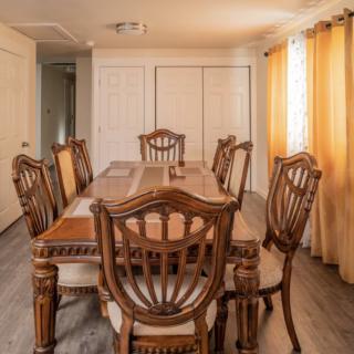 A warmly lit dining room with a wooden dining table and chairs.