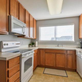 A modern kitchen with wood cabinets and stainless steel appliances.