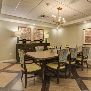 A well-designed dining room with a large table and chairs, elegant lighting, and artwork on the walls.