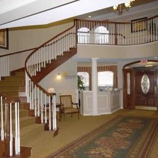 An elegant interior lobby with a curved staircase and classic furnishings.