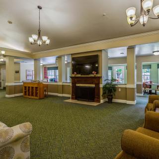 A spacious living room with comfortable furniture, a fireplace, and a TV.