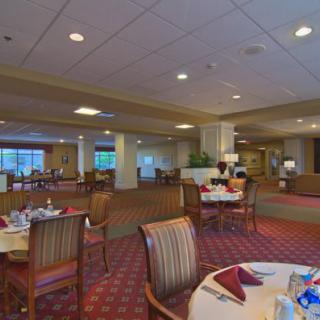 A spacious dining room with elegantly set tables and comfortable seating arrangements.