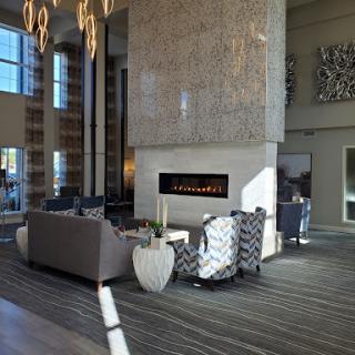 A stylish and modern lobby featuring comfortable seating, a cozy fireplace, and elegant lighting.