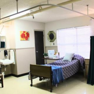 A hospital room with a single bed and medical equipment.