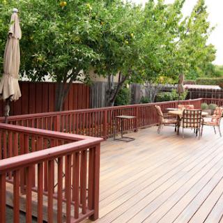 A serene outdoor deck area surrounded by lush greenery and comfortable seating.