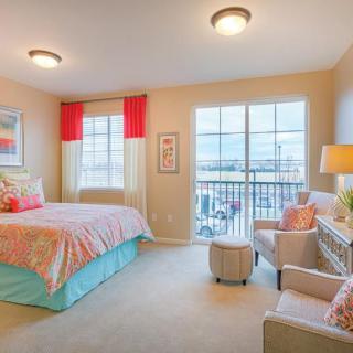 A cozy and colorful bedroom with bright accents and ample natural light.