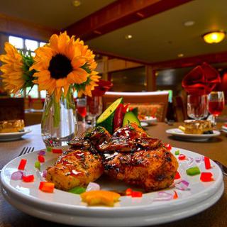 A beautifully plated gourmet dish with a vibrant sunflower centerpiece in an elegant dining setting.