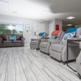 A cozy and modern living room featuring comfortable recliners and a stylish couch with colorful cushions.