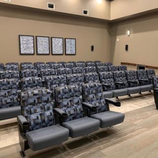 A modern auditorium seating area with patterned chairs and a warm color palette.