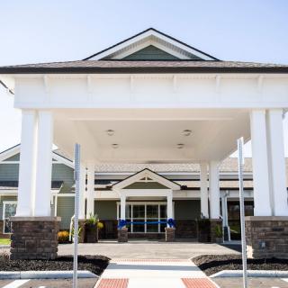 The entrance of a modern building with a large canopy and columns.