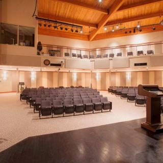 An empty auditorium with rows of seating and a stage area.