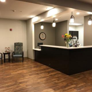 A modern reception area with a wooden floor and a stylish desk.