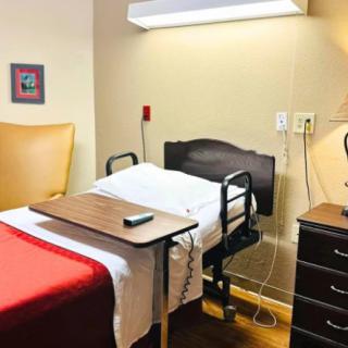 A neatly arranged hospital room with a bed and medical equipment.