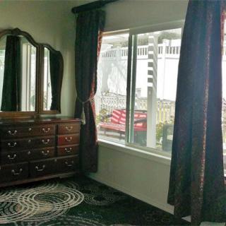 A cozy bedroom with a vintage dresser and mirror near the window.
