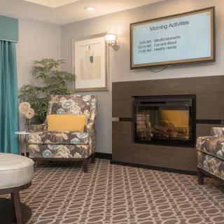 Comfortable living room with a fireplace, TV, and patterned chairs.