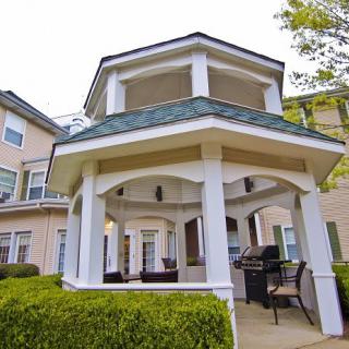 A charming gazebo provides a cozy outdoor seating area in a well-maintained garden.