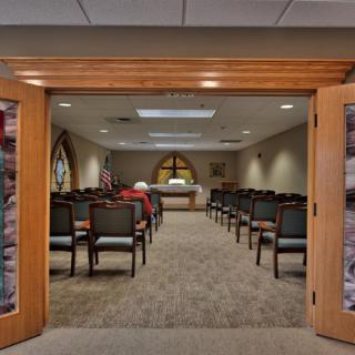 A small chapel with rows of chairs facing an altar.