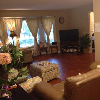 A cozy living room with comfortable seating, television, and warm lighting.
