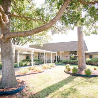 A charming house surrounded by lush greenery and a well-maintained garden.