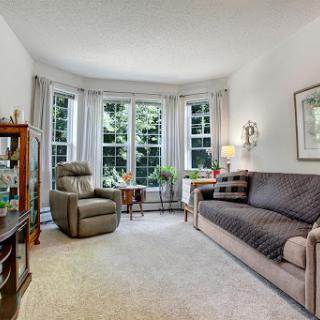 A cozy and bright living room with a comfortable couch and recliner, perfect for relaxation.